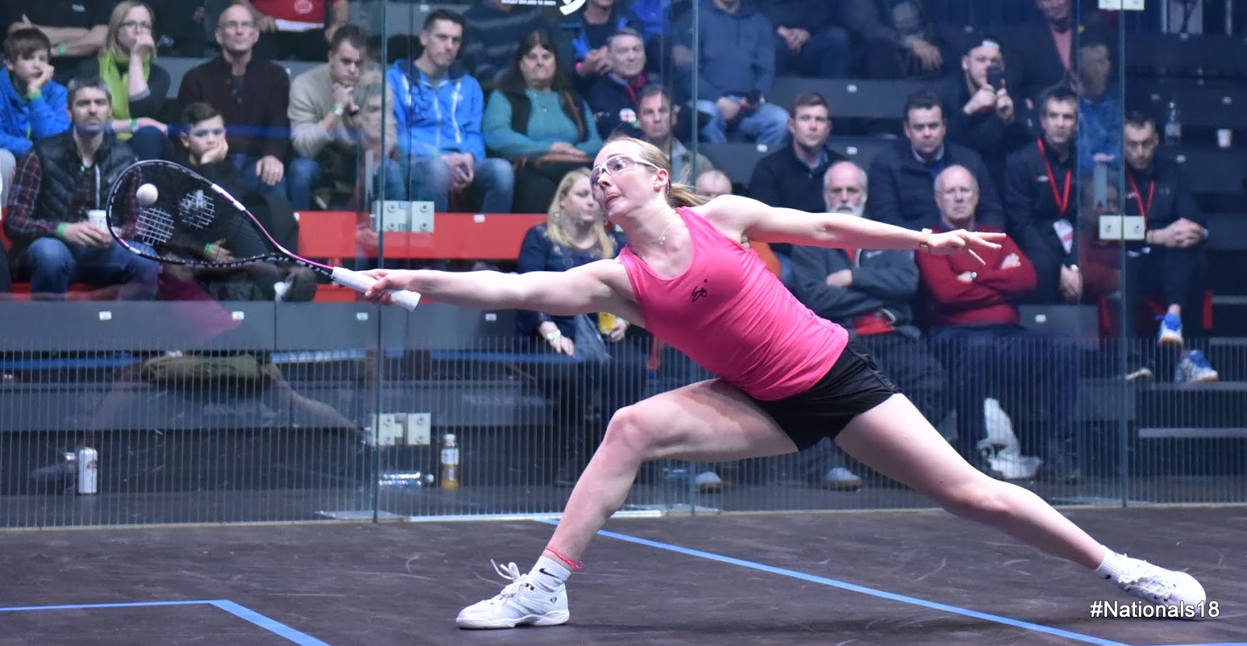Lucy Turmel in a match on a glass court
